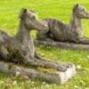 a pair of recumbent garden dog statuesa pair of recumbent garden dog statues