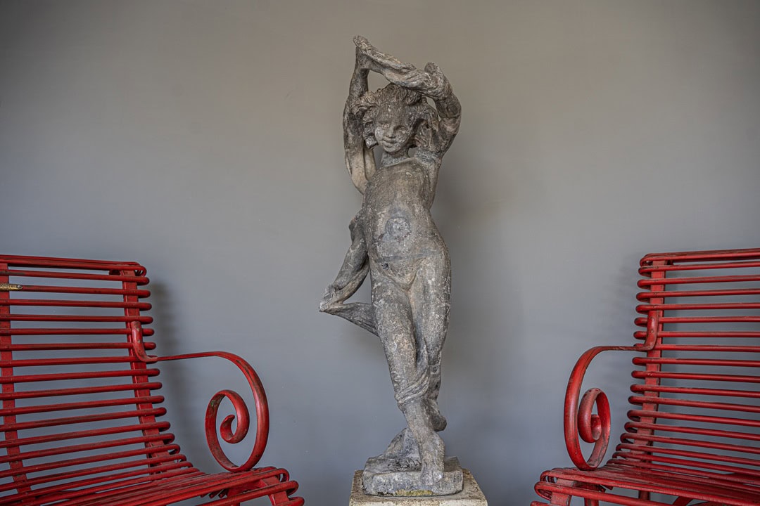 an antique lead garden cherub statue