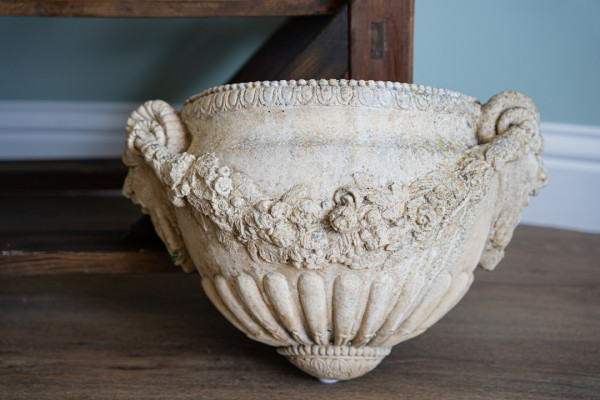 mask detail on a pair of wall planters for the garden