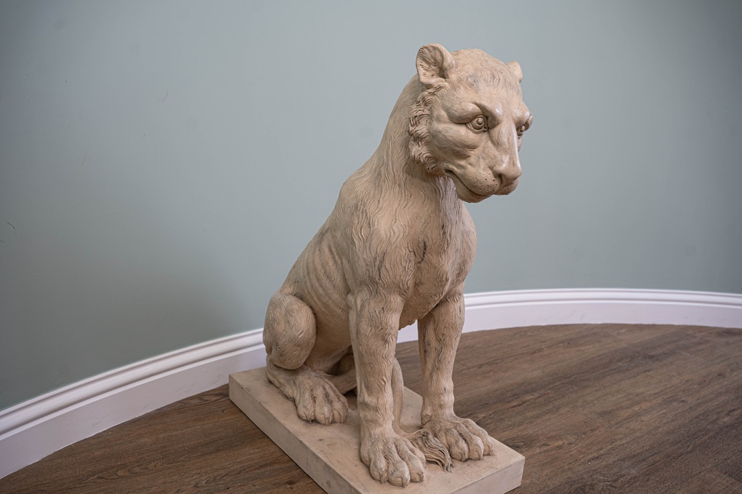 a garden statue of a young lion or tiger