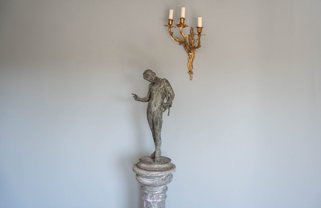 an antique bronze sculpture of Narcissus