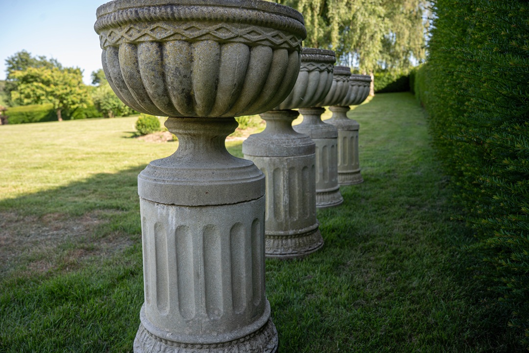set of four garden urns on plinths