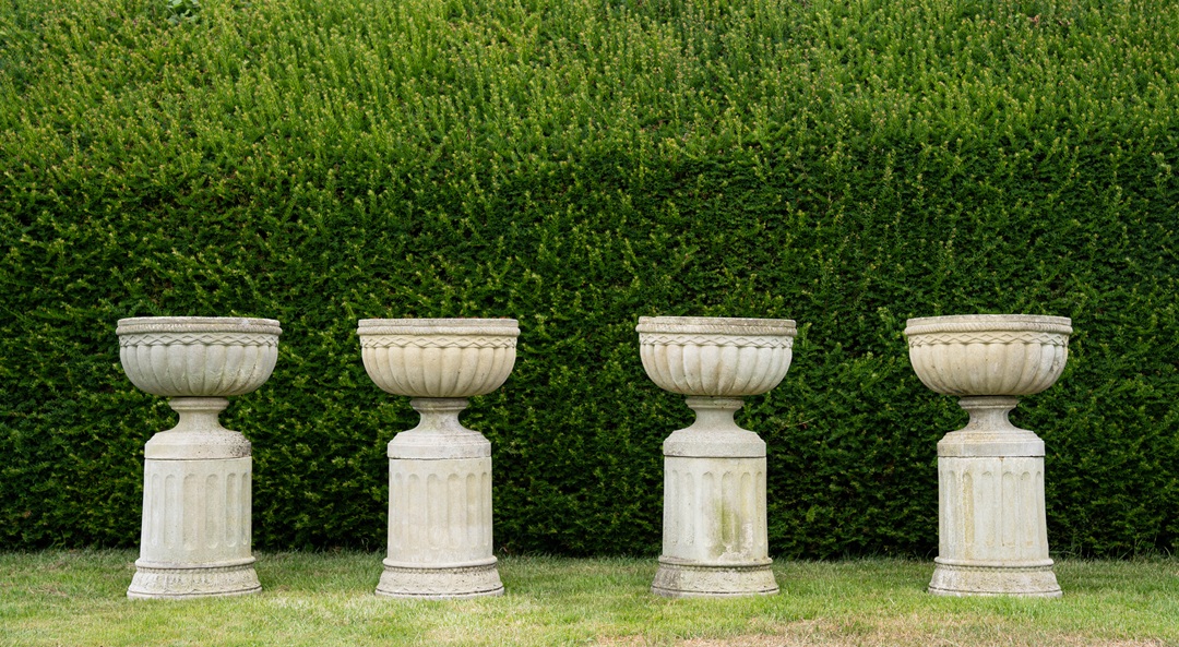 set of matching cast stone vintage garden urns on plinths