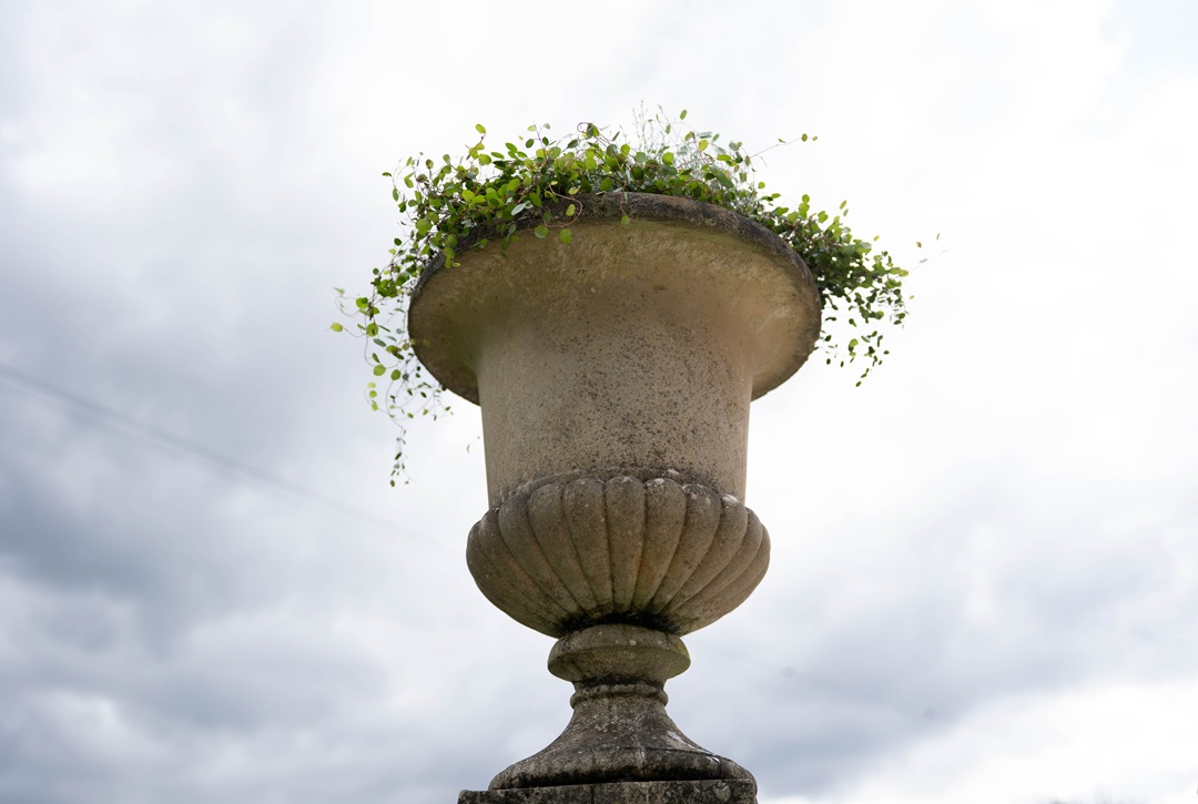 a pair of cast stone antique garden urns on plinths for sale