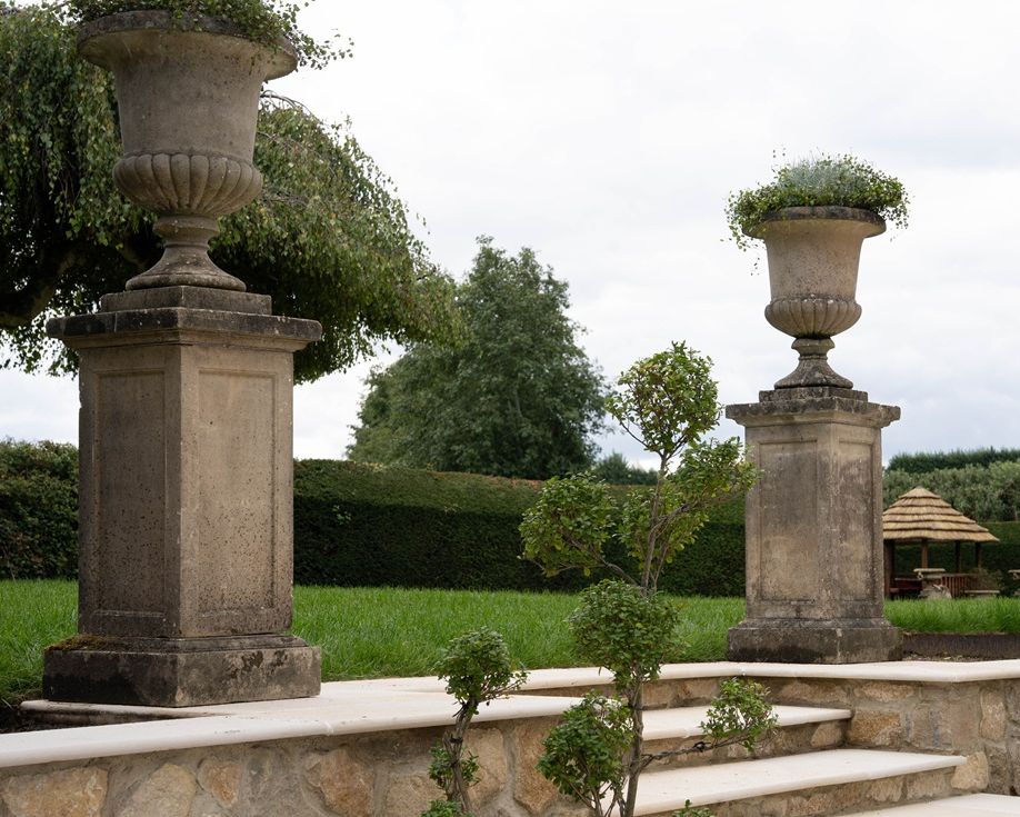 pair antique garden urns on plinths